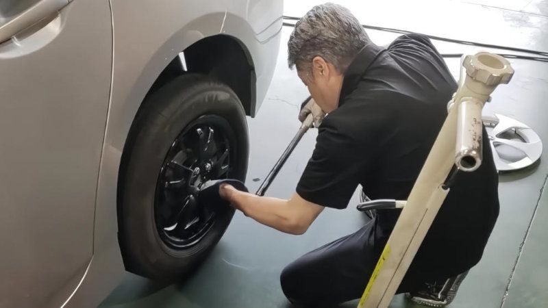 インパクトレンチを使い、車両のハブにホイールを慎重に取り付けている作業風景